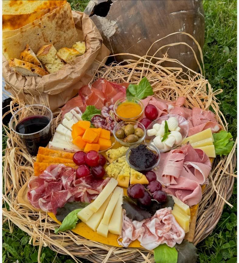 Grande tagliere di formaggi sardi, salumi e pane carasau con vino Cannonau