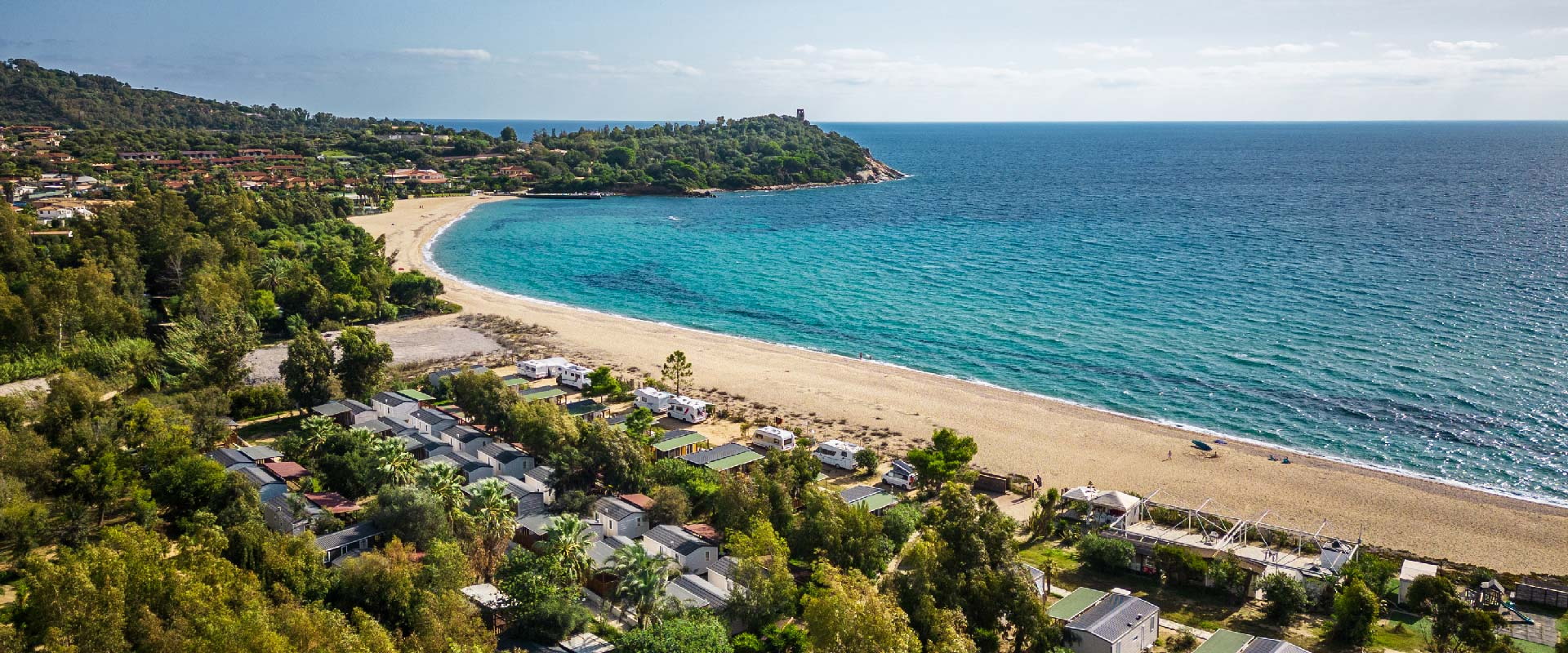 Curved sandy beach and turquoise sea along the Ogliastra coast seen from above