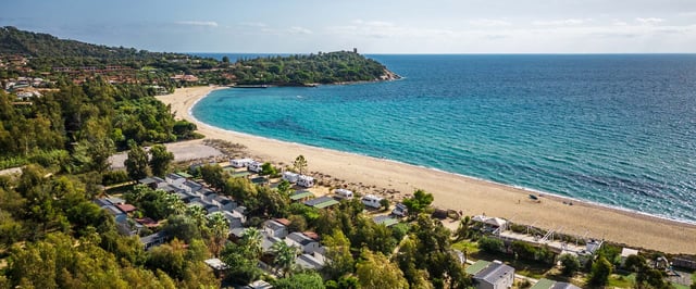 Veduta aerea del Campeggio Villaggio Sos Flores affacciato sulla spiaggia e sul mare turchese