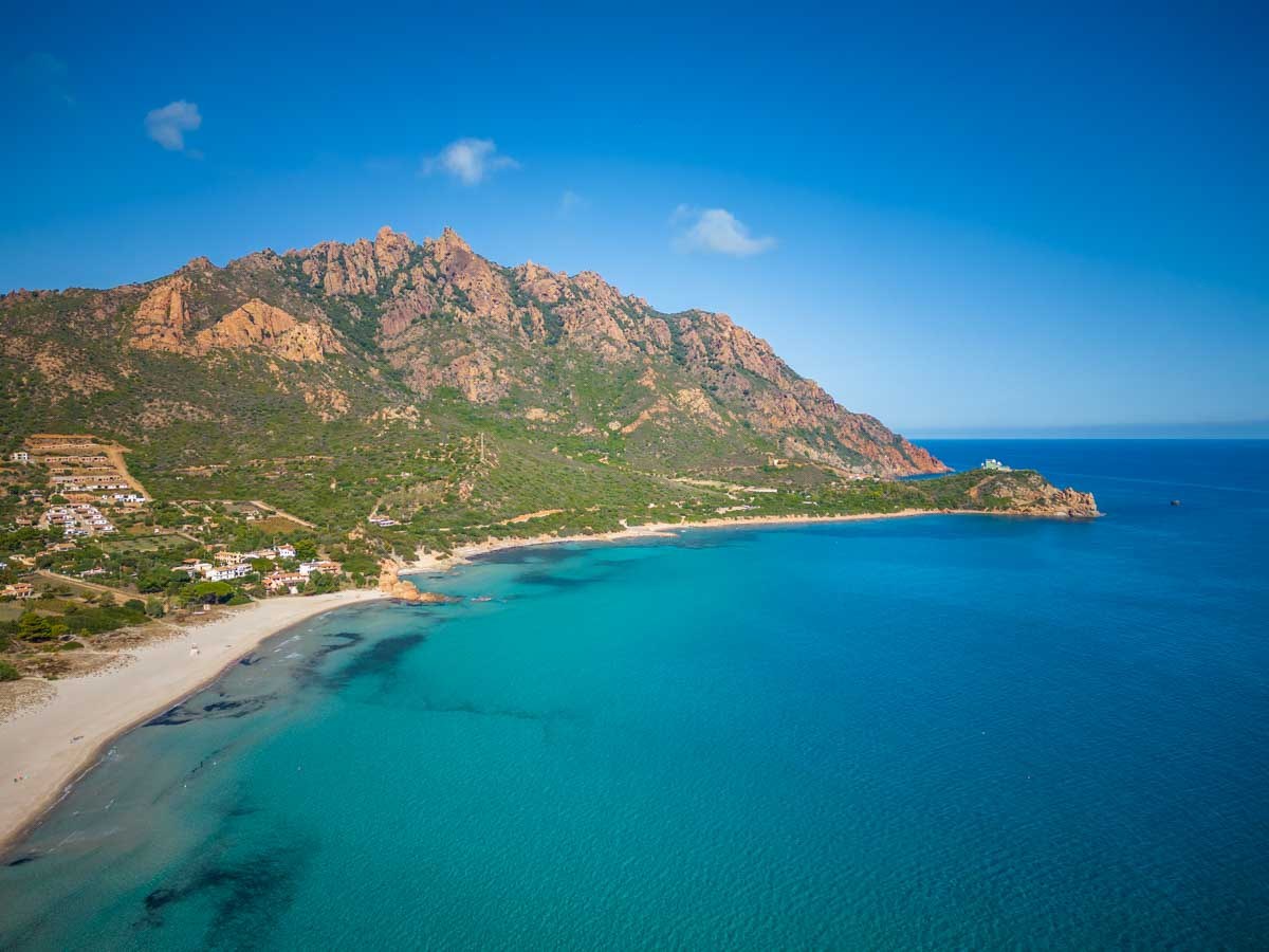 Veduta aerea della costa dell'Ogliastra con spiaggia, promontorio roccioso e mare turchese