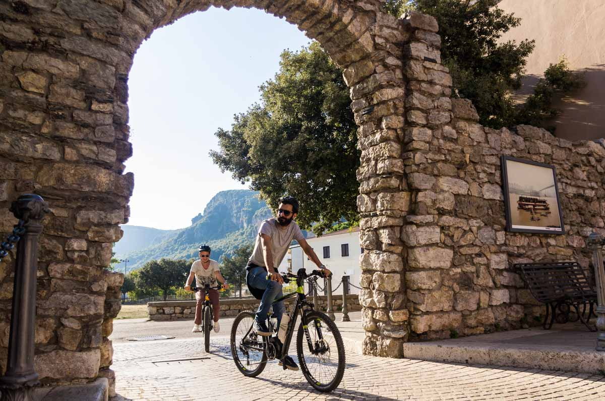 Bicicletta sotto un arco in pietra nel borgo di Ulassai