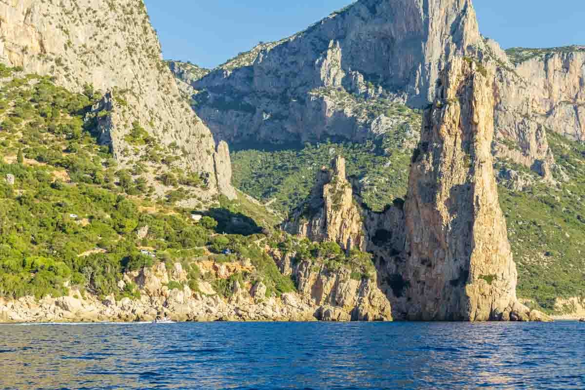 Falesie calcaree della costa di Baunei che si tuffano nel mare, viste dalla barca